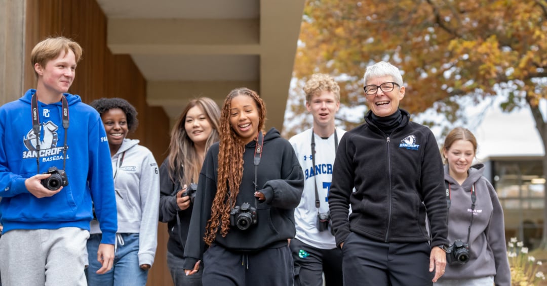 High school students in a photography class walk through campus with cameras in their hands at Bancroft School in Worcester, MA
